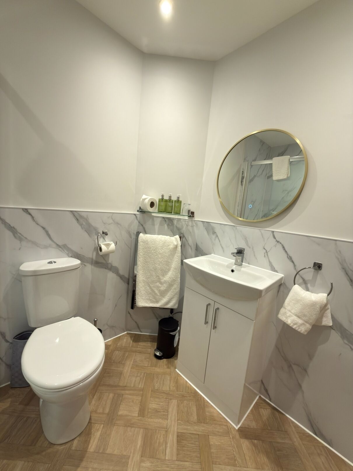 A modern bathroom with a toilet, sink, and mirror.