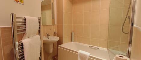 Une salle de bain équipée d’une baignoire, de toilettes, d’un lavabo et d’un porte-serviettes.