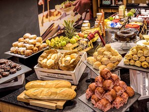 A buffet with various food items including pastries, bread, and fruits. - ibis Aracaju (Aracaju)