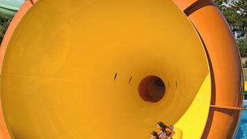A large indoor water slide with a yellow interior and a pool at the bottom.