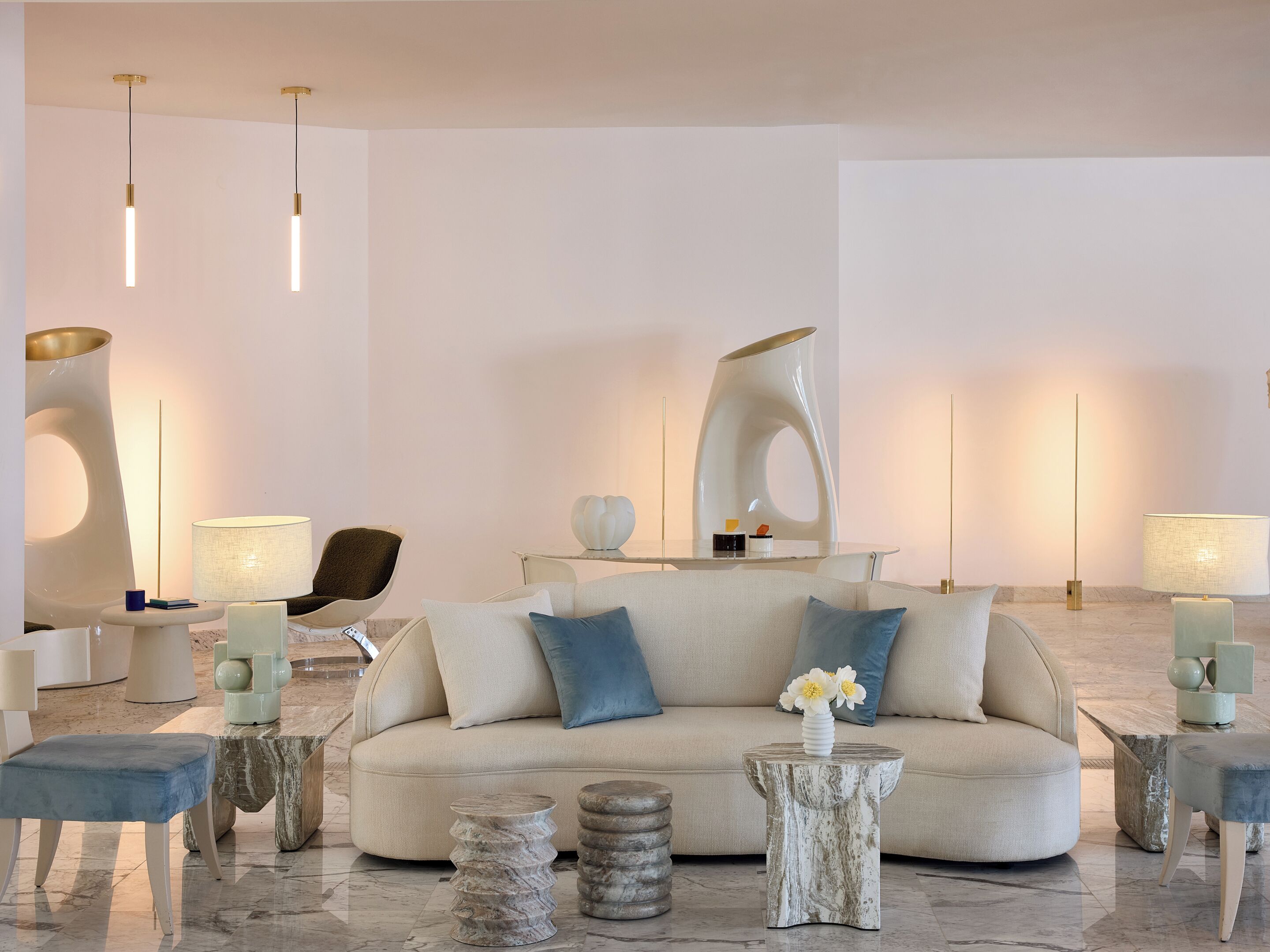 A modern living room with a sofa, side tables, a chair, and decorative lamps.