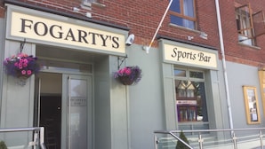 En bygning med et skilt, der viser ”FOGARTY'S” og ”Sports Bar”.