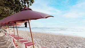 A beach with rows of sun loungers and umbrellas. - MATCHA SAMUI RESORT (Koh Samui)