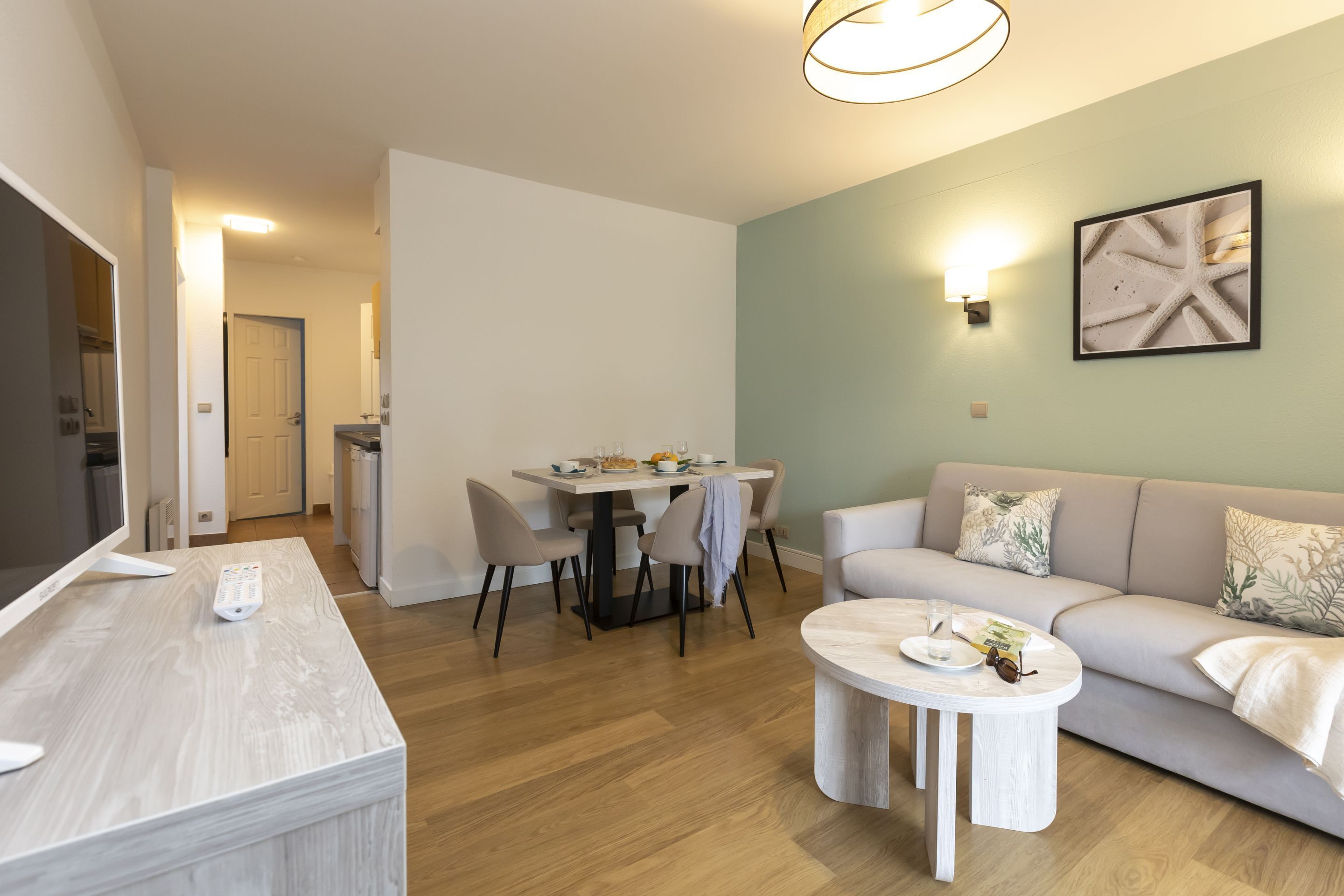 Ein modernes Wohnzimmer mit Sofa, Couchtisch und Essbereich.
