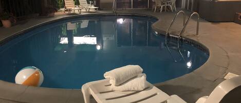 An indoor swimming pool with lounge chairs and a 'NO DIVING' sign.
