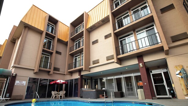 A hotel with a pool, outdoor seating, and a 'No Diving' sign.
