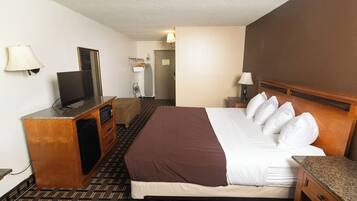 A hotel room with a bed, a television, a desk, and a mirror.