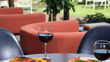 Un espace extérieur aménagé pour prendre les repas, avec deux pizzas, des verres à vin et une assiette de chips.