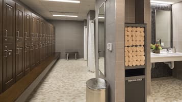 Clean and organized men's restroom with lockers, bench, and towel rack.