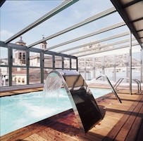 Una piscina cubierta, sombrillas, tumbonas