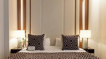 A hotel room with a large bed, two nightstands, and two lamps.