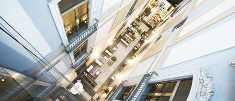 A multi-level shopping mall with glass railings, ornate architectural details, and multiple floors.
