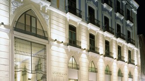 Un bâtiment historique doté d’arcades et de balcons, dont la façade porte l’inscription « AMERIGO ».