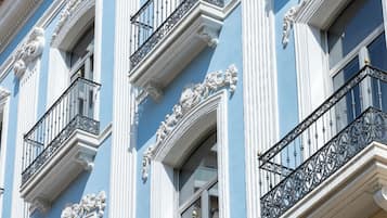 Une façade d’immeuble ornée de balcons décoratifs et présentant des éléments architecturaux classiques.
