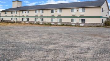 A two-story motel with a gravel parking lot.