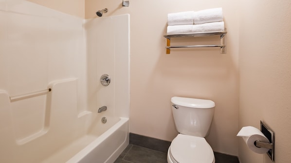 A bathroom with a bathtub, toilet, and towel rack.