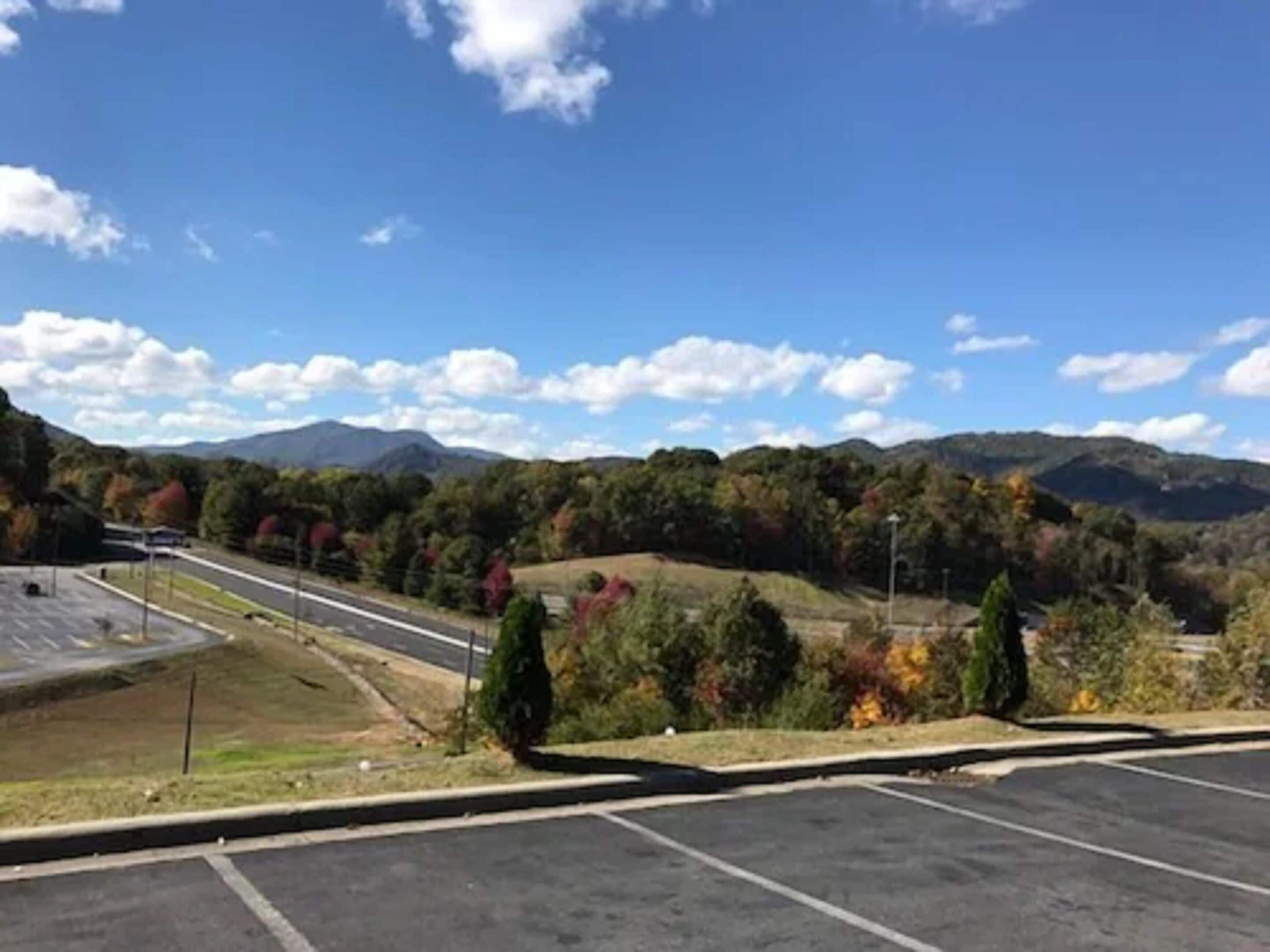 A parking lot with a view of mountains and autumn foliage.