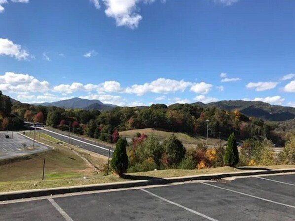A parking lot with a view of mountains and autumn foliage.