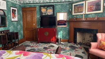 Ein Zimmer mit einem Bett, einem Fernseher, einem Kamin und einer Tür.