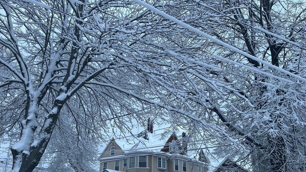 A two-story house with a snow-covered roof and a porch. - The Munroe Inn (Auburn)