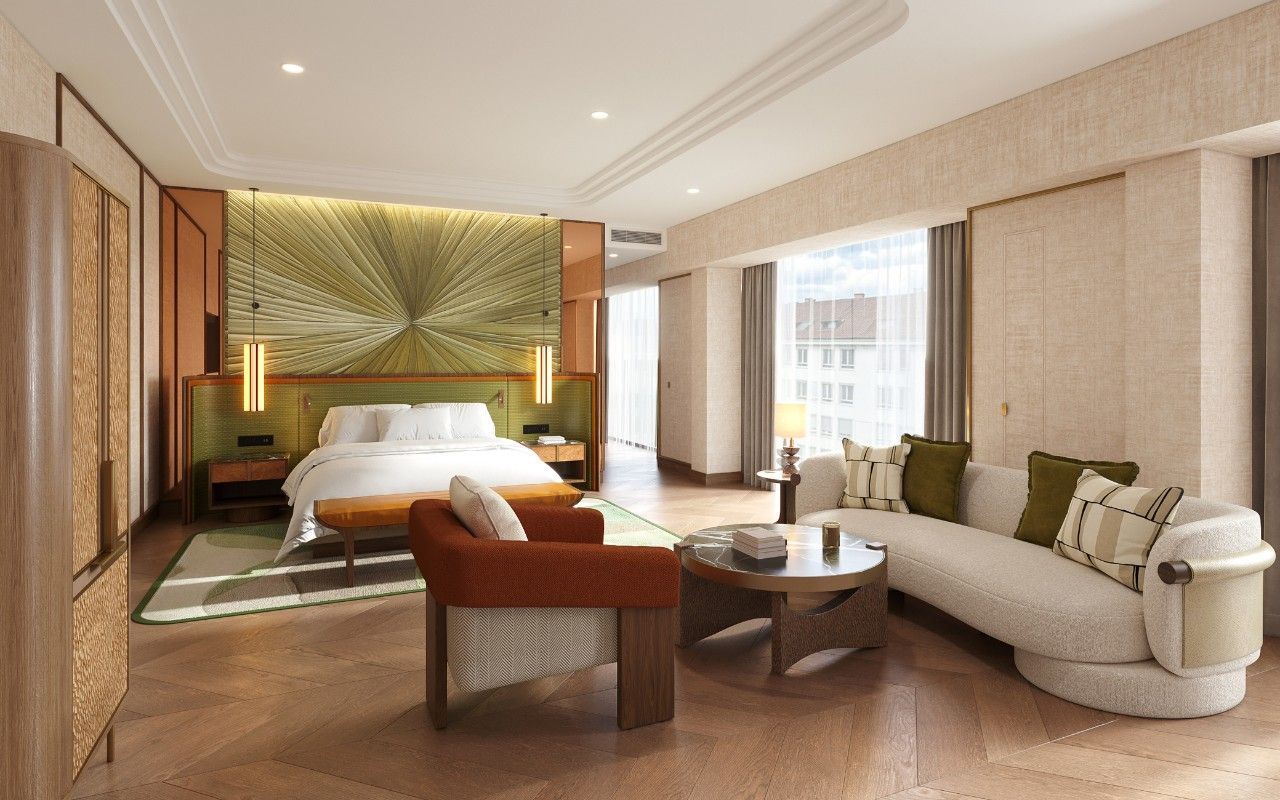 A hotel room with a large bed, a sofa, a coffee table, and a view of the city.