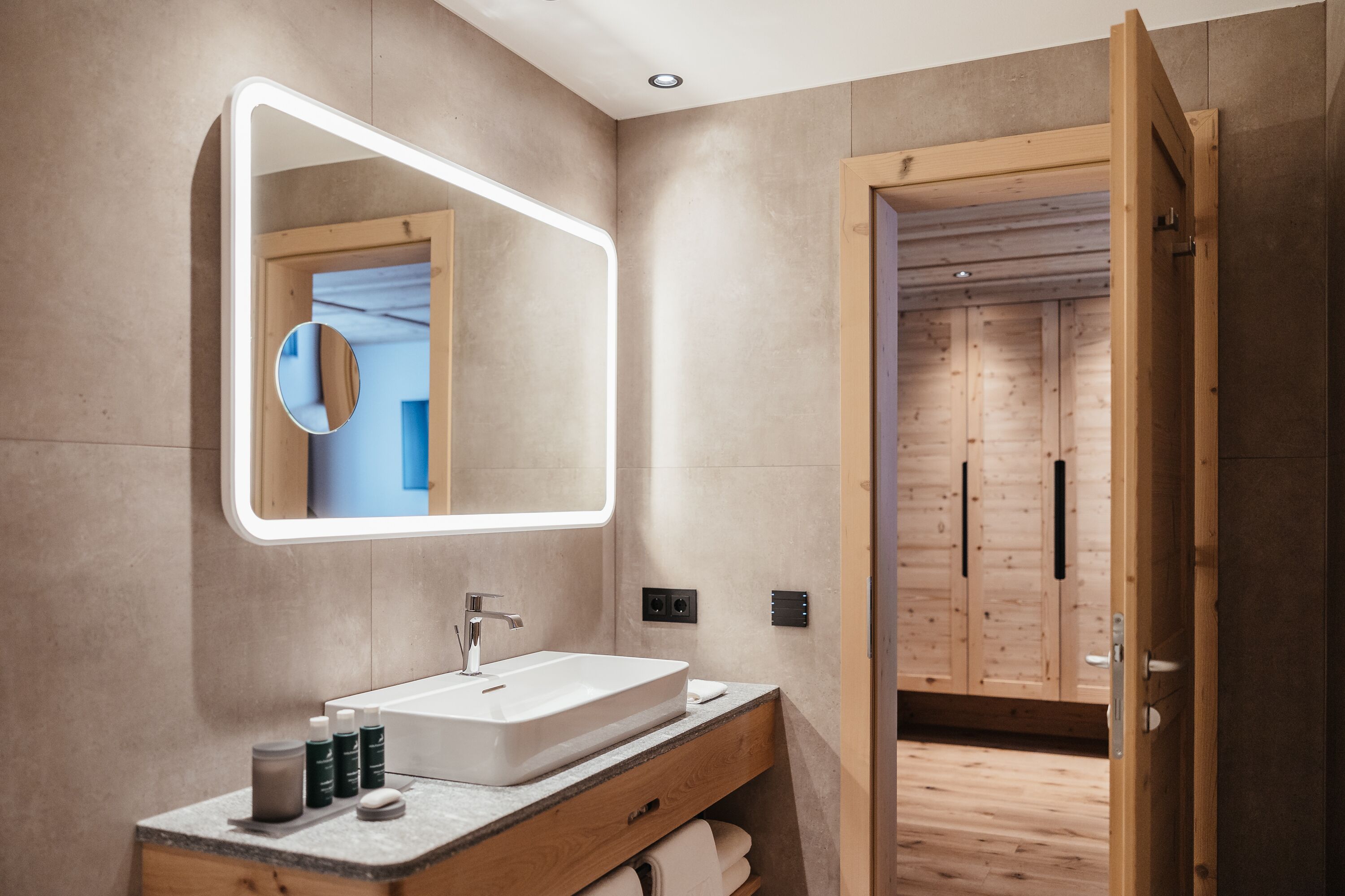 Un bagno moderno con uno specchio grande, un lavabo e pensili in legno.