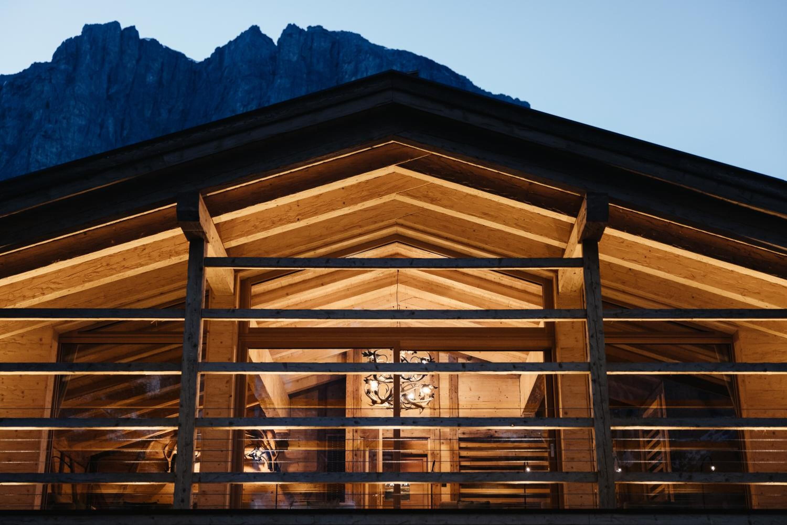 Una baita di legno con tetto a spiovente e struttura interna a vista.