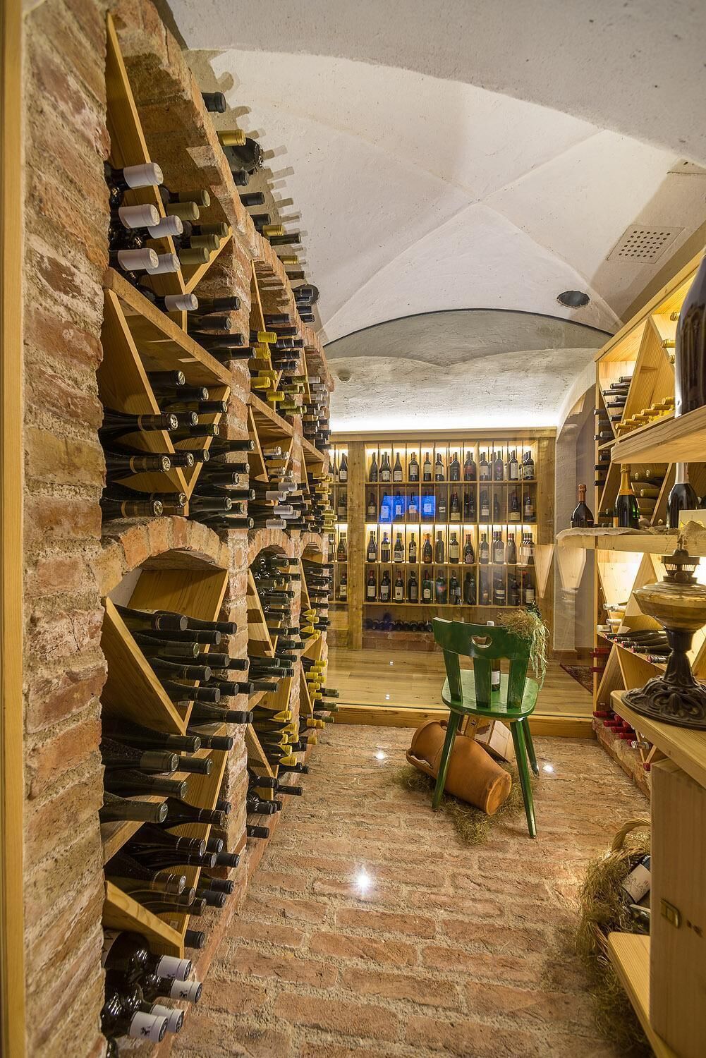 A wine cellar with wooden racks and shelves filled with wine bottles.