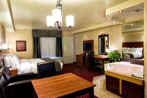 A hotel room with a bed, a desk, a chair, a table, a bathroom with a bathtub, and a mirror. - Hotel - Motel Coconut (Trois-Rivieres)