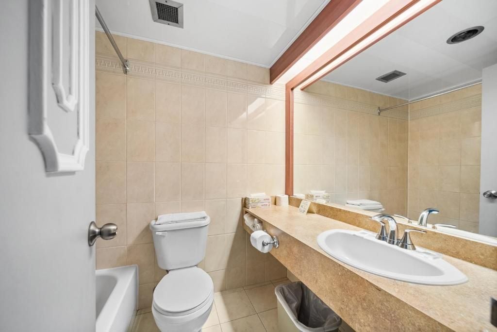 Une salle de bain moderne équipée de toilettes, d’un lavabo et d’une douche.