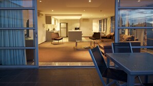 An open-plan living area with a kitchen, dining table, and seating. - Zero Davey Boutique Hotel (Hobart)