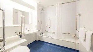 Une salle de bain comprenant des toilettes, un lavabo et un espace douche.