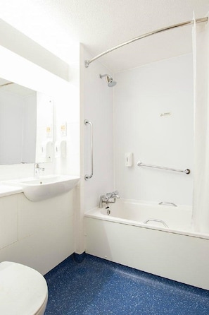 A bathroom with a white sink, mirror, and bathtub. - Travelodge Washington A1 Northbound (Chester-le-Street)