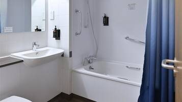 A modern bathroom with a bathtub, shower, sink, and toilet.