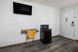 Escritorio, cortinas blackout y tabla de planchar con plancha 