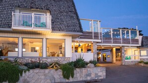 A modern two-story house with a stone facade, large windows, and a balcony. - Cambria Beach Lodge (Cambria)