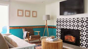 A living room with a fireplace, a television, and a patterned wall.