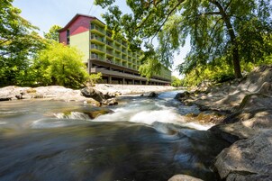 A hotel with a multi-story structure, a parking garage, and a river flowing through the property.