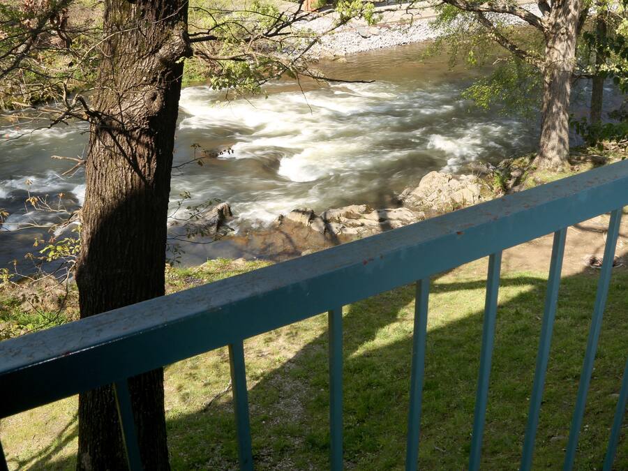 A river with a railing in the foreground.