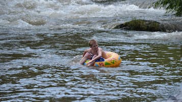 Una persona sentada en un flotador de colores en un río caudaloso.