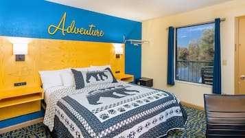A hotel room with a bed, a nightstand, a desk, a chair, a window with a view, and a wall with the word "Adventure" written on it.
