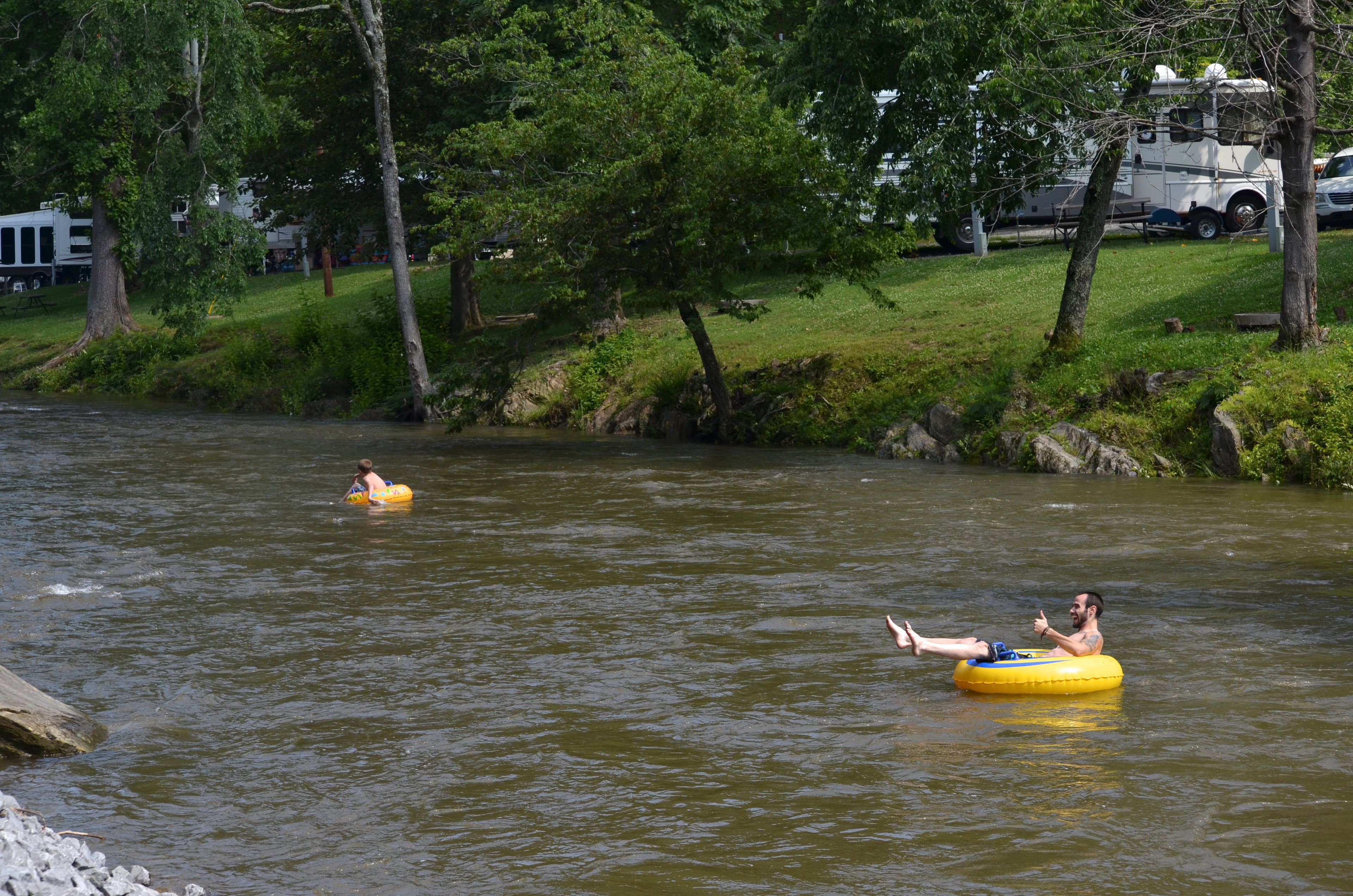 Two people floating on a river in inflatable tubes.