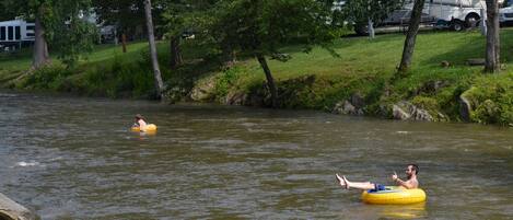 Dos personas flotando en un río sobre flotadores.