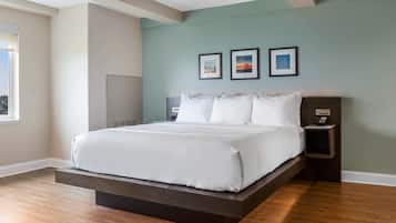 A modern bedroom with a platform bed, a nightstand, and a wall-mounted alarm clock.