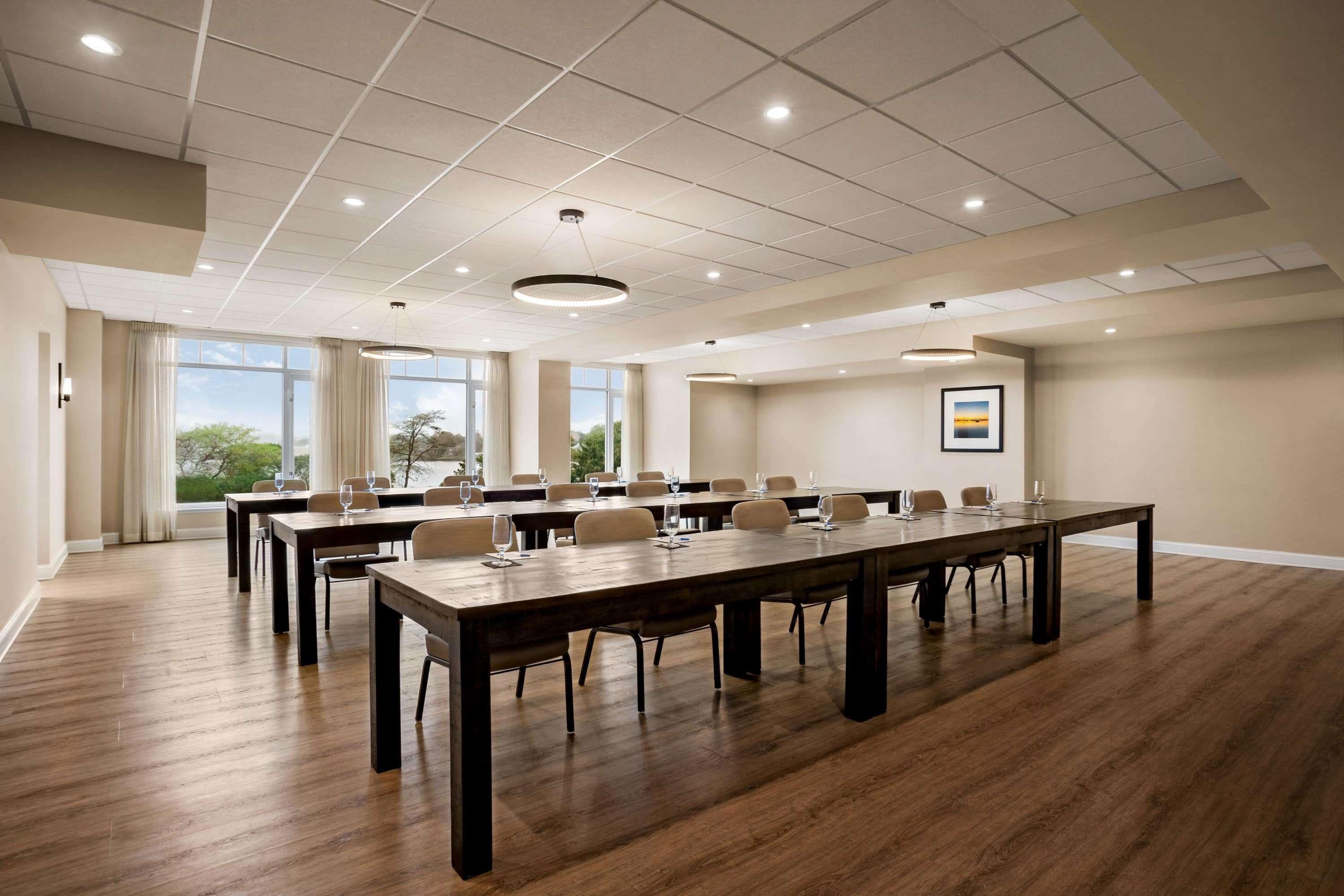 Een vergaderzaal met een lange tafel, stoelen en een plafond met inbouwverlichting.