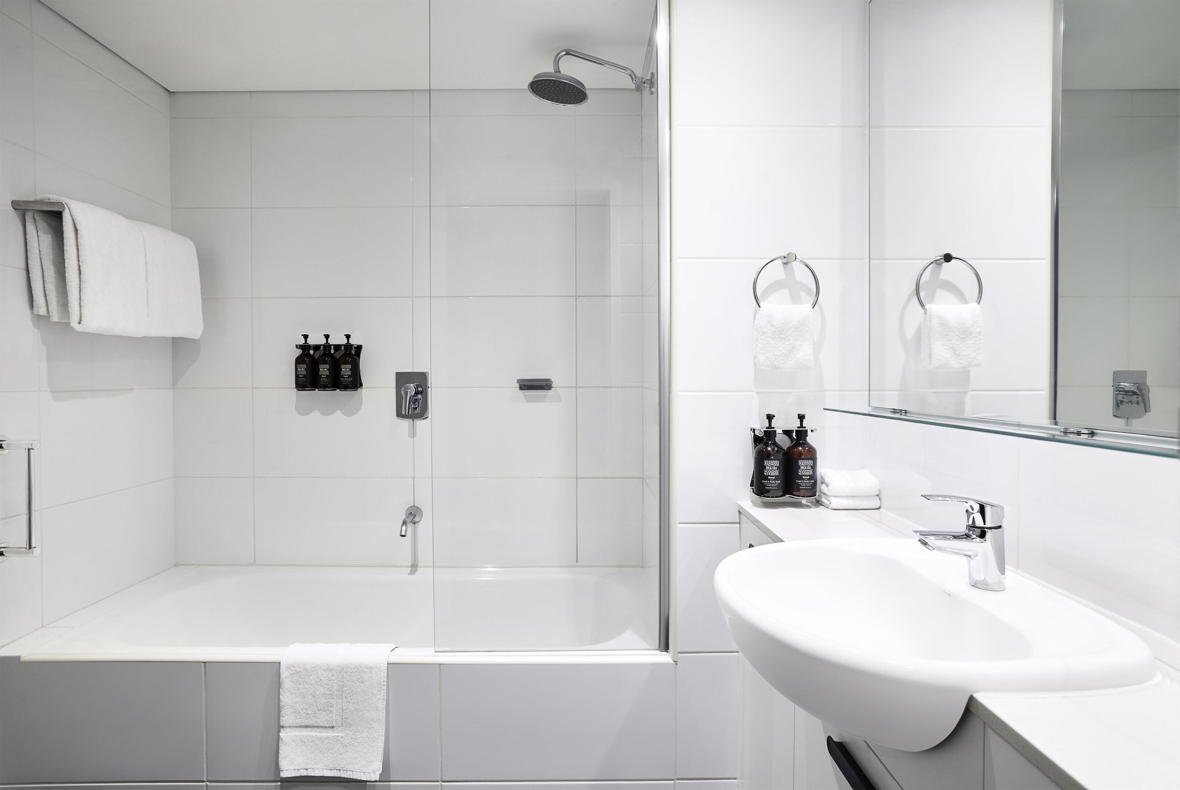 Een moderne badkamer met een inloopdouche, een badkuip en een wastafel.