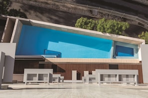 Relax by the rectangular pool surrounded by a light-colored deck and contemporary benches.