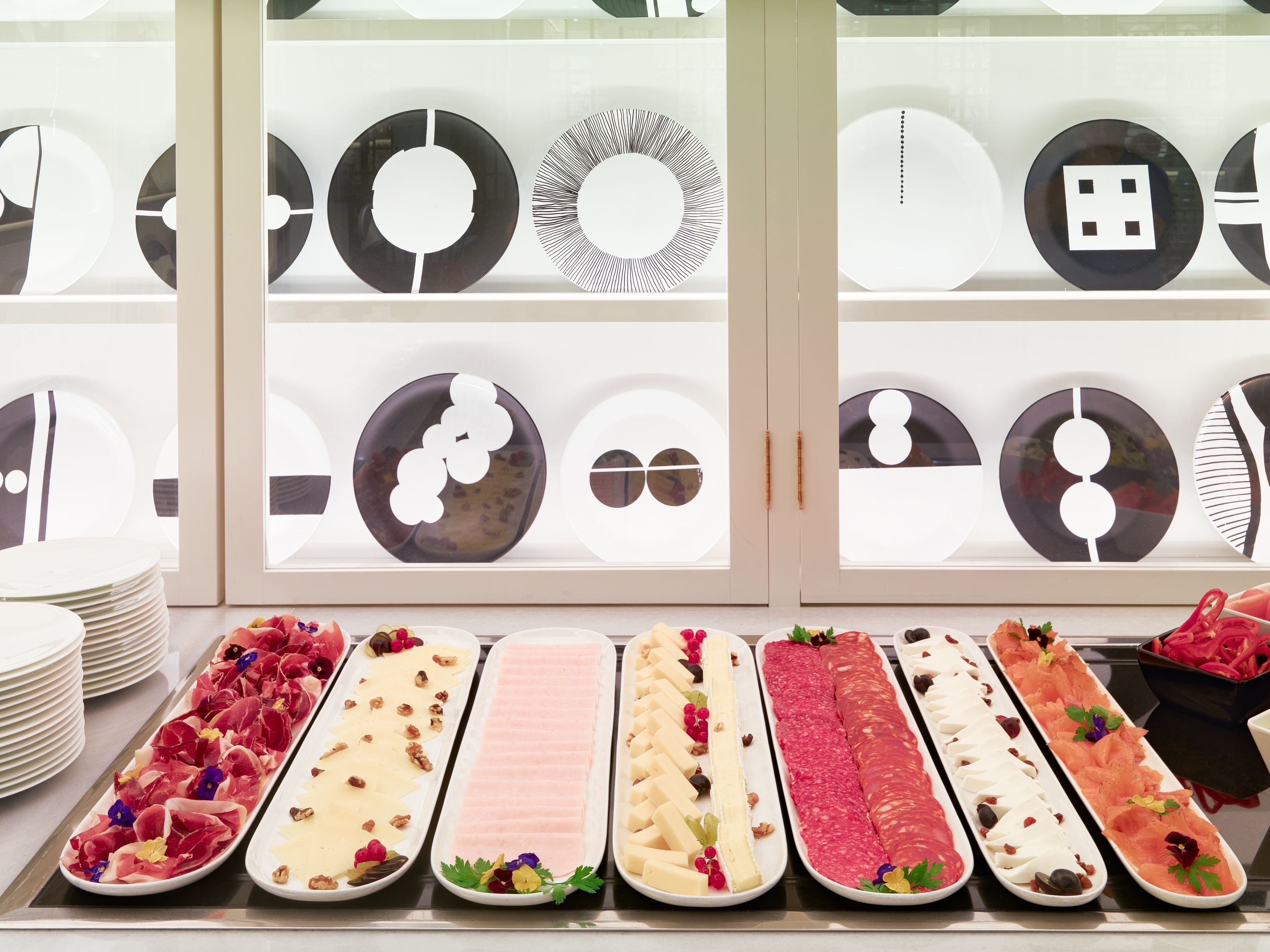 A display of various food platters with different types of meats and cheeses, arranged on a counter.