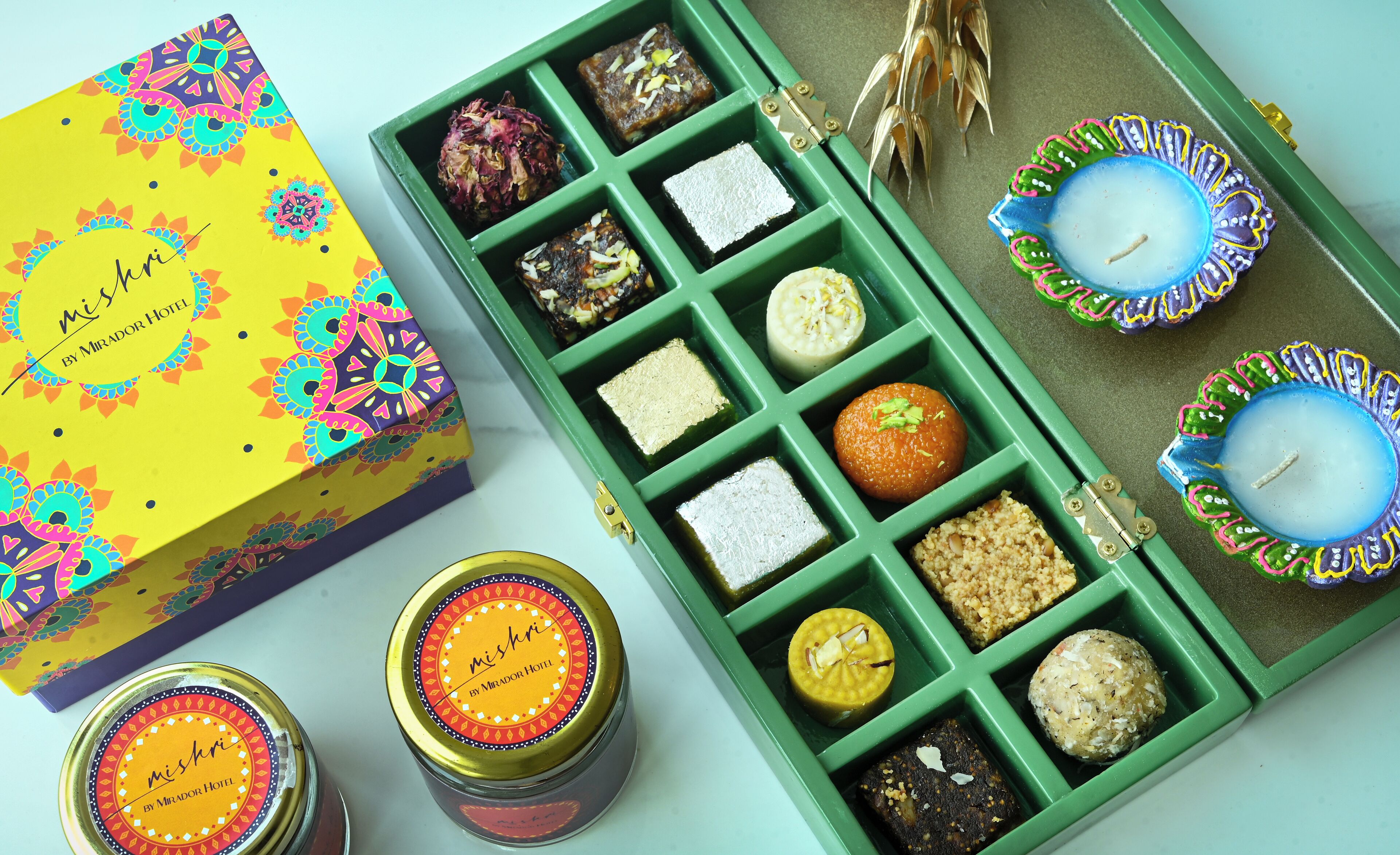 A collection of sweets and candles in a green box with a colorful label.
