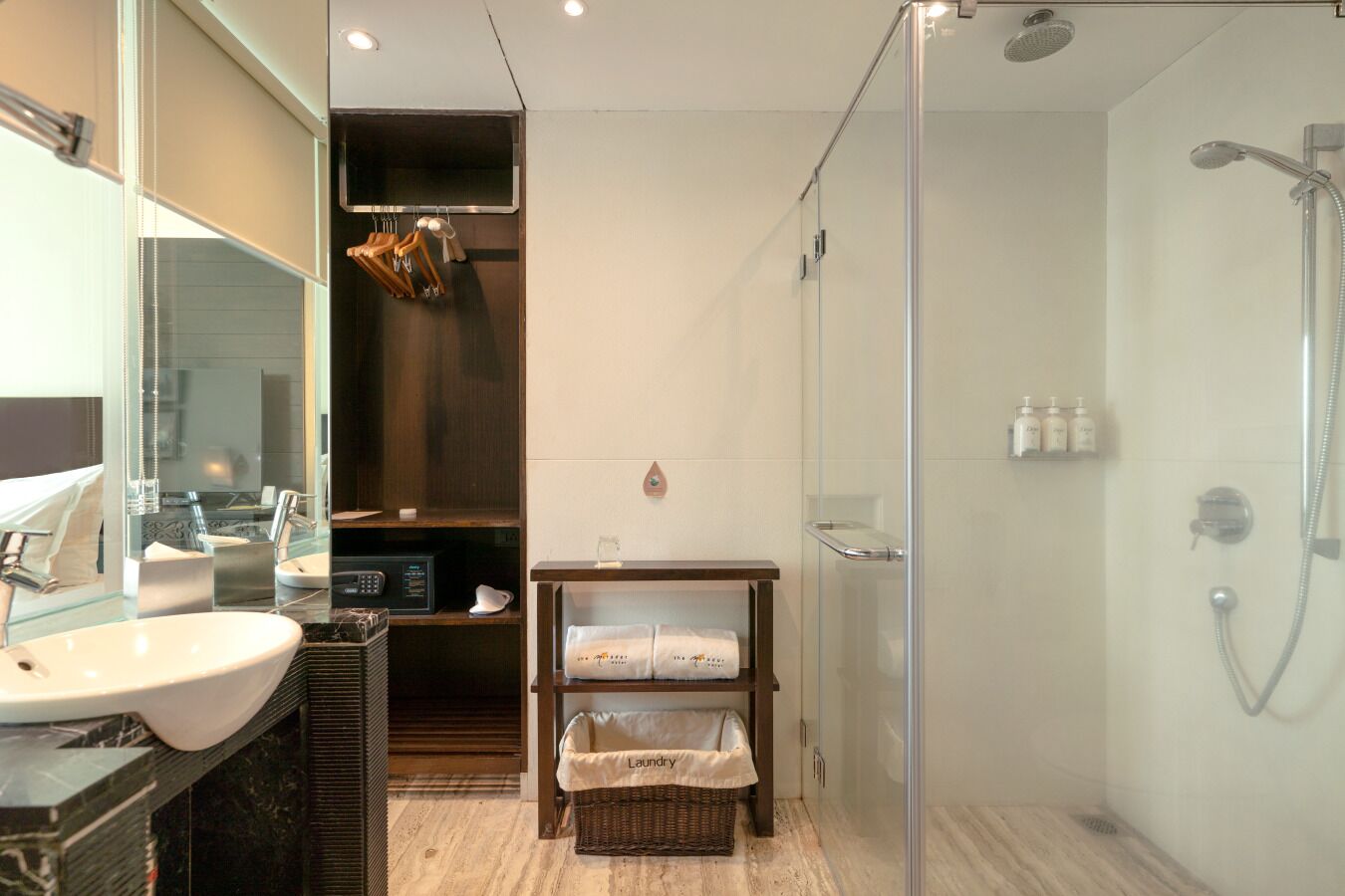 A modern bathroom with a glass shower enclosure, a sink, and a mirror.